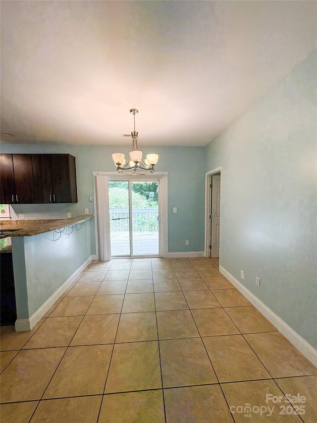 3430 Fincher Blvd, Charlotte, NC 28269 - unfurnished dining area featuring a chandelier, light tile patterned flooring, and baseboards