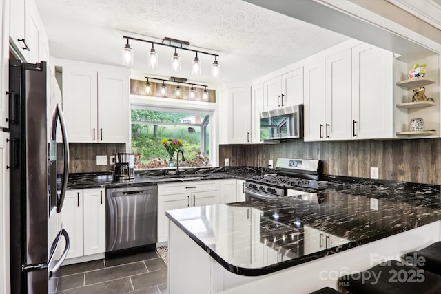 68 Broyles Rd, Hendersonville, NC 28791 - kitchen featuring appliances with stainless steel finishes, a sink, a peninsula, open shelves, and tasteful backsplash