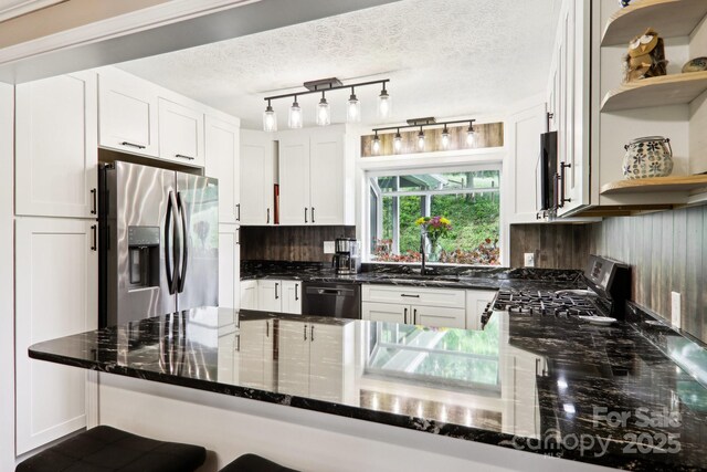 68 Broyles Rd, Hendersonville, NC 28791 - kitchen with stainless steel appliances, a sink, open shelves, dark stone countertops, and white cabinetry