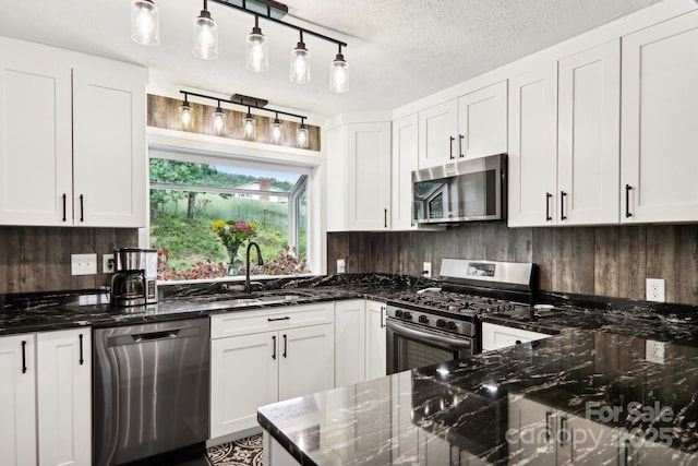68 Broyles Rd, Hendersonville, NC 28791 - kitchen featuring appliances with stainless steel finishes, a sink, white cabinetry, dark stone counters, and a textured ceiling