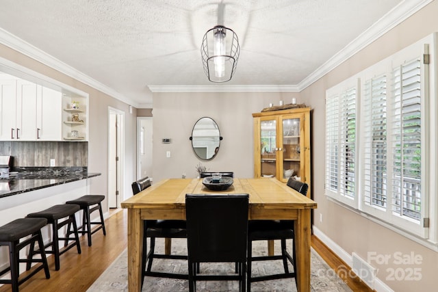68 Broyles Rd, Hendersonville, NC 28791 - dining area featuring healthy amount of natural light, light wood-style floors, crown molding, and a textured ceiling