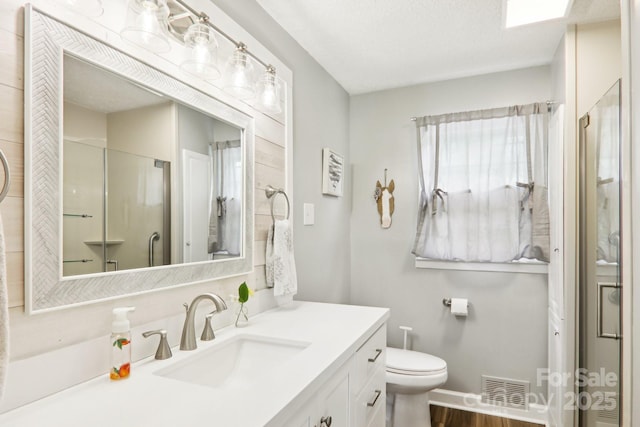 68 Broyles Rd, Hendersonville, NC 28791 - full bathroom with vanity, toilet, a shower with door, wood finished floors, and baseboards