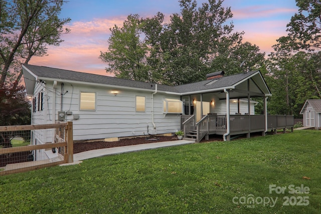 68 Broyles Rd, Hendersonville, NC 28791 - back of property at dusk with a lawn and a wooden deck
