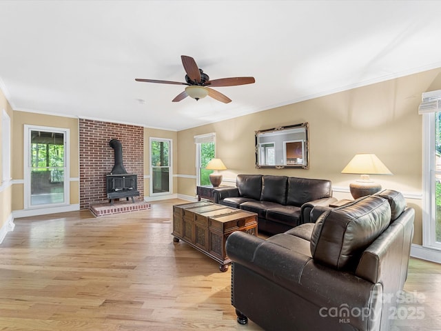 10710 Bristlecone Ct, Mint Hill, NC 28227 - living area featuring a wood stove, ornamental molding, light wood finished floors, plenty of natural light, and ceiling fan