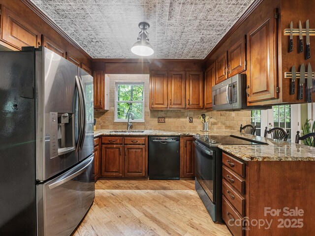10710 Bristlecone Ct, Mint Hill, NC 28227 - kitchen with black appliances, light wood-style floors, crown molding, decorative backsplash, and light stone countertops