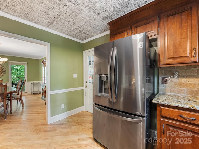 10710 Bristlecone Ct, Mint Hill, NC 28227 - kitchen featuring stainless steel refrigerator with ice dispenser, crown molding, light wood-type flooring, tasteful backsplash, and brown cabinets