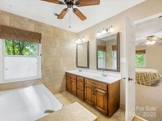 10710 Bristlecone Ct, Mint Hill, NC 28227 - ensuite bathroom with ceiling fan, double vanity, a bathtub, and tile walls