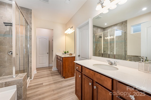 705 Hinterland Ln, Matthews, NC 28104 - bathroom with a stall shower, two vanities, wood finished floors, and a bath