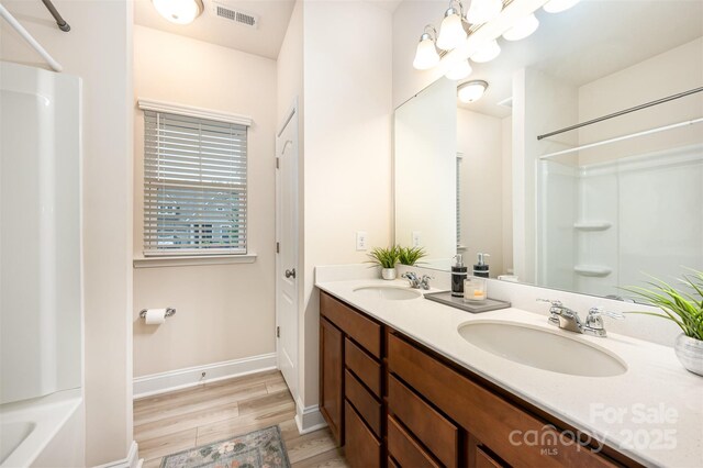 705 Hinterland Ln, Matthews, NC 28104 - full bathroom featuring double vanity, wood finished floors, and baseboards