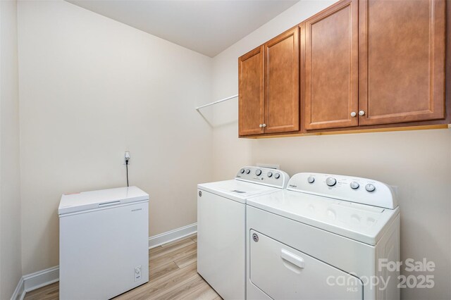 705 Hinterland Ln, Matthews, NC 28104 - laundry room featuring independent washer and dryer, cabinet space, baseboards, and light wood-style flooring