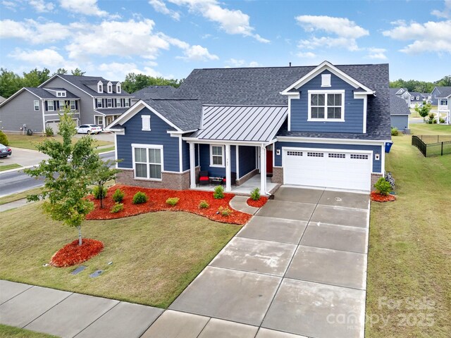 705 Hinterland Ln, Matthews, NC 28104 - view of front of home with covered porch, brick siding, a standing seam roof, and driveway