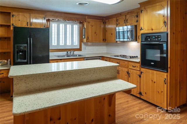 6487 NC-18 Rd, Connelly Springs, NC 28612 - kitchen featuring black appliances, a sink, a center island, light wood finished floors, and backsplash