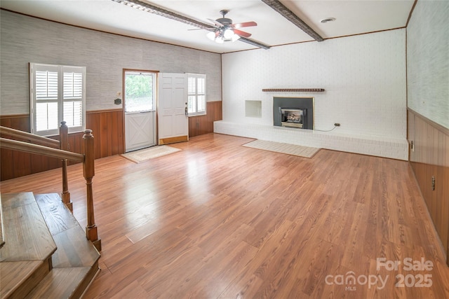 6487 NC-18 Rd, Connelly Springs, NC 28612 - unfurnished living room featuring ceiling fan, light wood-style flooring, a brick fireplace, a wainscoted wall, and beamed ceiling