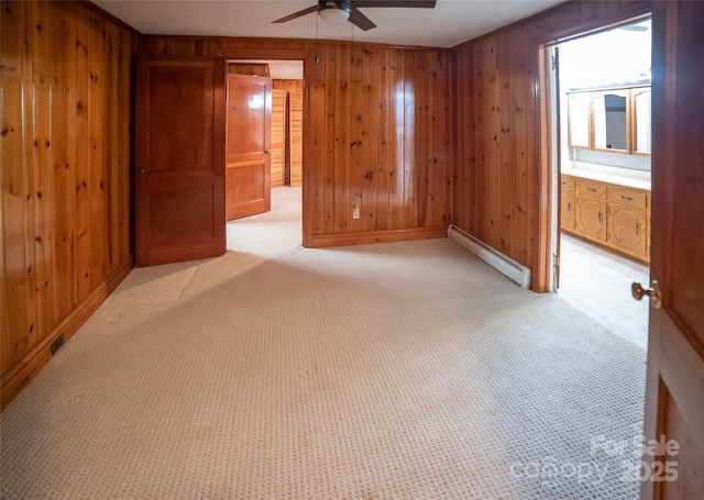 6487 NC-18 Rd, Connelly Springs, NC 28612 - unfurnished room featuring a baseboard heating unit, wooden walls, a ceiling fan, baseboards, and light colored carpet