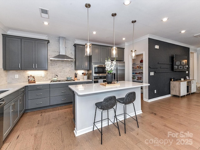 5811 Mantle Way, Kannapolis, NC 28081 - kitchen with wall chimney range hood, crown molding, appliances with stainless steel finishes, a breakfast bar area, and light wood finished floors