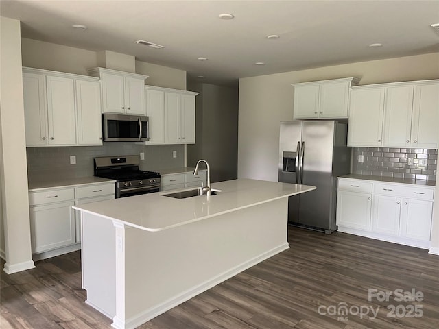 108 Red Juniper Way, Statesville, NC 28625 - kitchen featuring appliances with stainless steel finishes, a sink, dark wood-type flooring, decorative backsplash, and white cabinetry