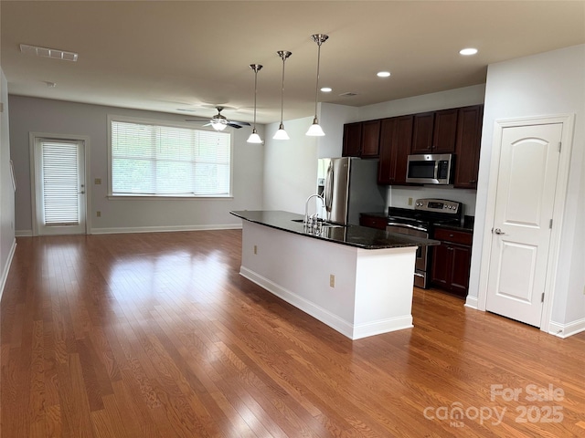 129 Steinbeck Way Unit B, Mooresville, NC 28117 - kitchen with appliances with stainless steel finishes, dark countertops, a sink, wood finished floors, and recessed lighting