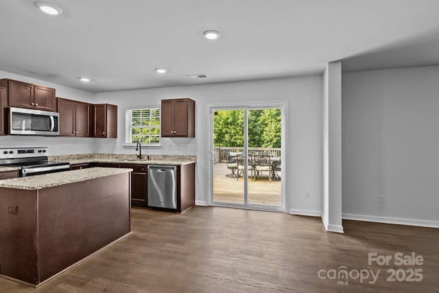 2021 Tarzi Ln, Charlotte, NC 28215 - kitchen featuring stainless steel appliances, dark wood-style floors, dark brown cabinetry, recessed lighting, and light stone counters