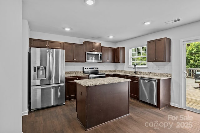 2021 Tarzi Ln, Charlotte, NC 28215 - kitchen with appliances with stainless steel finishes, dark brown cabinetry, healthy amount of natural light, dark wood finished floors, and recessed lighting
