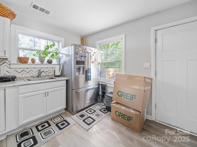 339 Arnold St, Rock Hill, SC 29730 - kitchen featuring stainless steel refrigerator with ice dispenser, a sink, light wood-type flooring, and white cabinets
