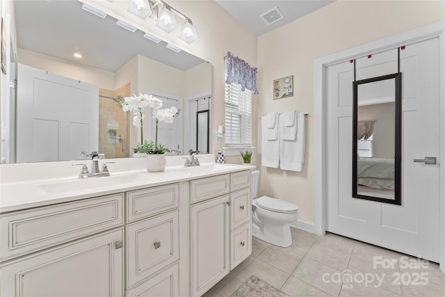 5079 Skyfest Dr, Charlotte, NC 28215 - full bathroom with double vanity, tile patterned floors, a tile shower, toilet, and baseboards