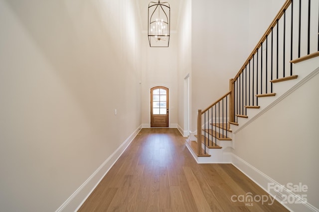 608 Deodar Cedar Dr Unit 69, Matthews, NC 28104 - entrance foyer featuring wood finished floors, a chandelier, baseboards, stairway, and a towering ceiling