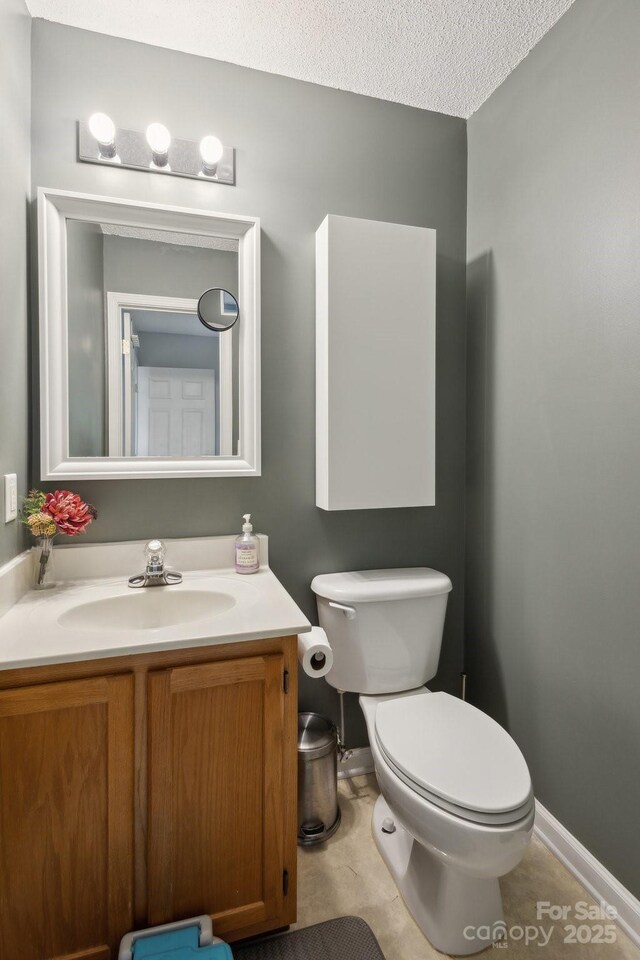 3721 Conway Ave, Charlotte, NC 28209 - half bathroom featuring toilet, vanity, and a textured ceiling
