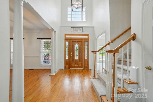 201 Limerick Dr, Matthews, NC 28104 - entryway featuring ornate columns, wood finished floors, stairway, a high ceiling, and ornamental molding