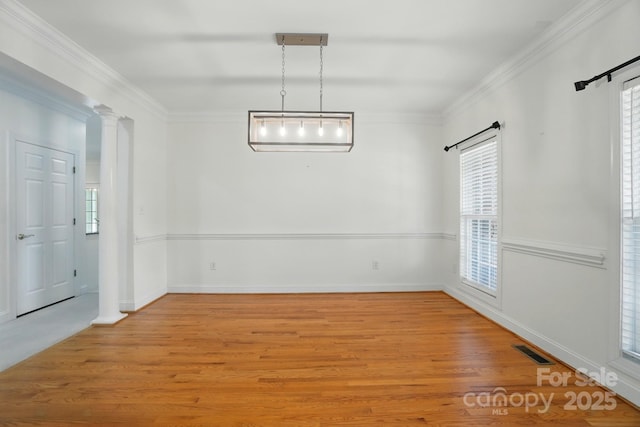 201 Limerick Dr, Matthews, NC 28104 - unfurnished dining area featuring light wood finished floors, ornate columns, plenty of natural light, and crown molding