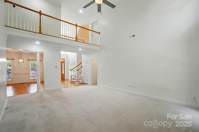 201 Limerick Dr, Matthews, NC 28104 - unfurnished living room featuring carpet flooring, ceiling fan, stairs, baseboards, and a high ceiling