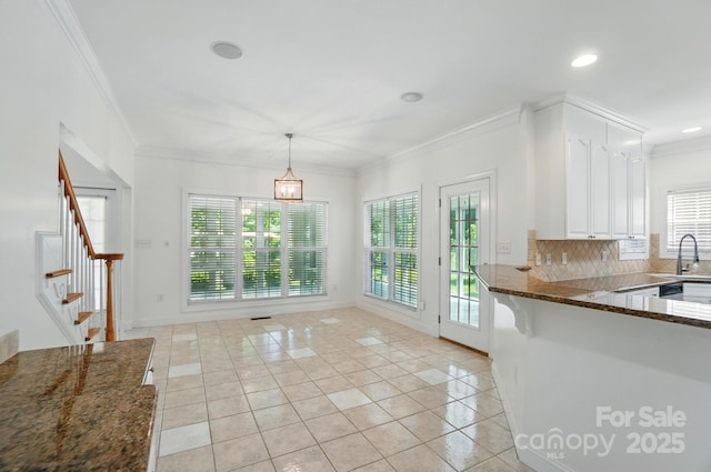 201 Limerick Dr, Matthews, NC 28104 - kitchen with light tile patterned flooring, healthy amount of natural light, white cabinetry, a sink, and ornamental molding