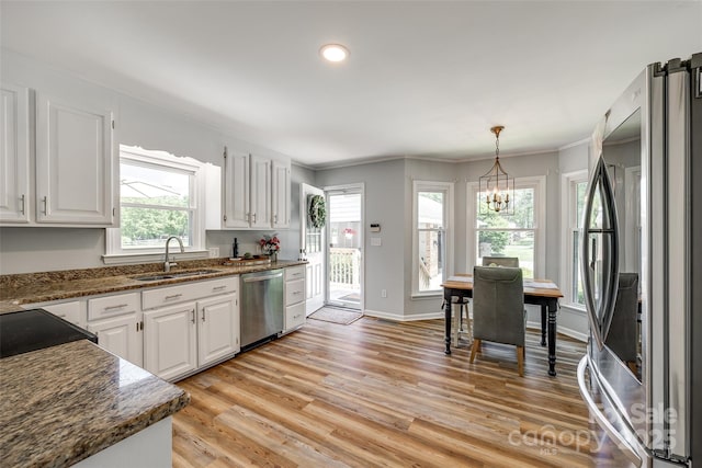7712 Old Waxhaw Monroe Rd, Waxhaw, NC 28173 - kitchen featuring appliances with stainless steel finishes, a sink, white cabinets, light wood-style flooring, and crown molding