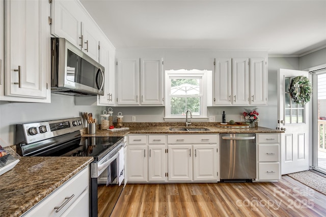 7712 Old Waxhaw Monroe Rd, Waxhaw, NC 28173 - kitchen with appliances with stainless steel finishes, a sink, healthy amount of natural light, light wood-style flooring, and ornamental molding