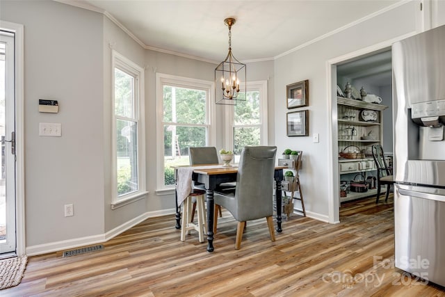 7712 Old Waxhaw Monroe Rd, Waxhaw, NC 28173 - dining space featuring a chandelier, light wood-style flooring, crown molding, and baseboards