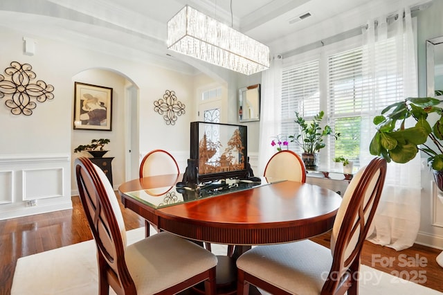 10903 Skymont Dr, Huntersville, NC 28078 - dining space with wood finished floors, arched walkways, wainscoting, a chandelier, and a decorative wall