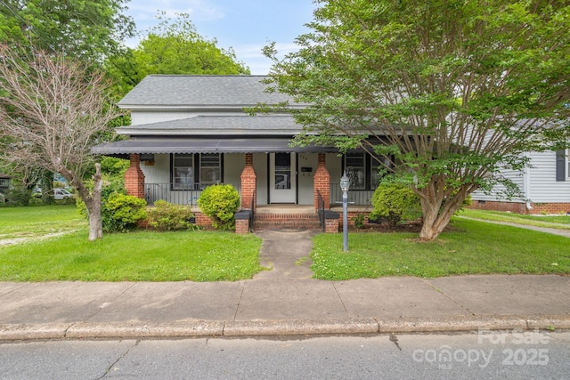 222 W Mccubbins St, Salisbury, NC 28144 - view of front of house featuring covered porch, roof with shingles, a front lawn, and brick siding