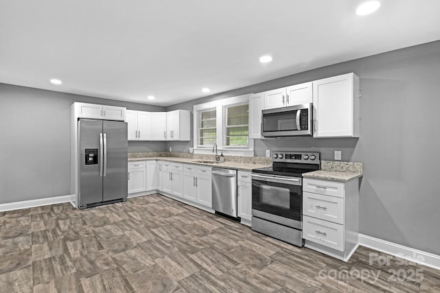 222 W Mccubbins St, Salisbury, NC 28144 - kitchen featuring stainless steel appliances, white cabinetry, light stone counters, recessed lighting, and a sink