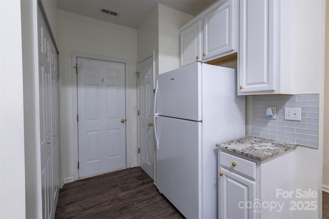 4637 Willow Glen Rd, Harrisburg, NC 28075 - kitchen featuring freestanding refrigerator, white cabinets, dark wood finished floors, tasteful backsplash, and light stone counters