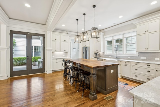 2221 Kenmore Ave, Charlotte, NC 28204 - kitchen featuring wooden counters, a sink, high quality fridge, a kitchen bar, and plenty of natural light