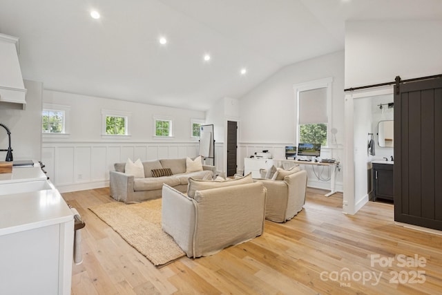2221 Kenmore Ave, Charlotte, NC 28204 - living area featuring a barn door, light wood finished floors, healthy amount of natural light, vaulted ceiling, and recessed lighting