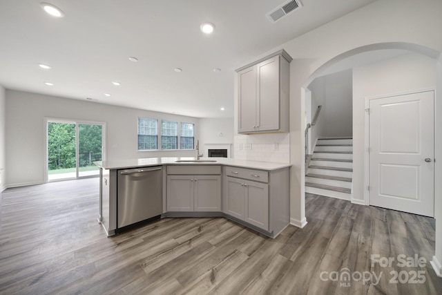 300 Kennerly Center Dr, Mooresville, NC 28115 - kitchen featuring stainless steel dishwasher, gray cabinetry, a sink, a peninsula, and wood finished floors