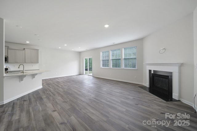 300 Kennerly Center Dr, Mooresville, NC 28115 - unfurnished living room with dark wood-style flooring, recessed lighting, baseboards, and a glass covered fireplace