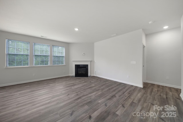 300 Kennerly Center Dr, Mooresville, NC 28115 - unfurnished living room featuring dark wood-style flooring, recessed lighting, a fireplace with flush hearth, and baseboards