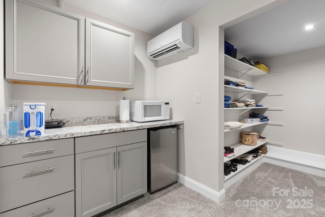 1035 15th Ave NW, Hickory, NC 28601 - kitchen with white microwave, refrigerator, gray cabinets, a wall unit AC, and baseboards
