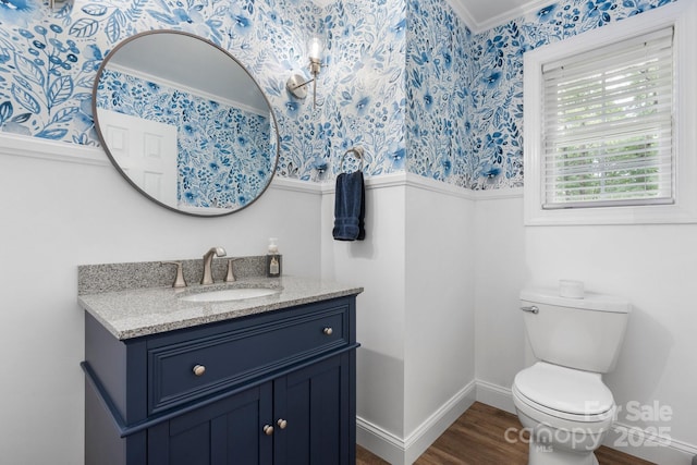 1035 15th Ave NW, Hickory, NC 28601 - bathroom featuring wallpapered walls, vanity, toilet, a wainscoted wall, and wood finished floors