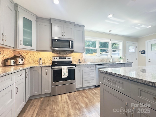 1035 15th Ave NW, Hickory, NC 28601 - kitchen with stainless steel appliances, crown molding, gray cabinetry, light wood-style flooring, and tasteful backsplash