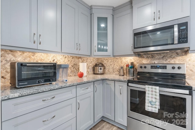 1035 15th Ave NW, Hickory, NC 28601 - kitchen with stainless steel appliances, backsplash, glass insert cabinets, and light stone countertops