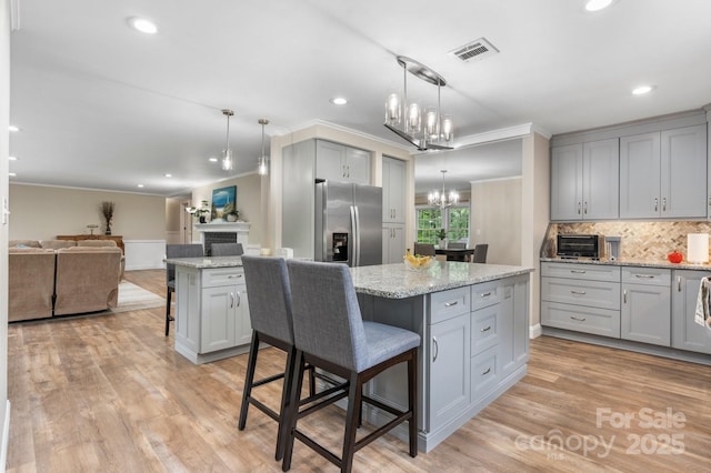 1035 15th Ave NW, Hickory, NC 28601 - kitchen with stainless steel fridge with ice dispenser, gray cabinets, crown molding, a center island, and a breakfast bar
