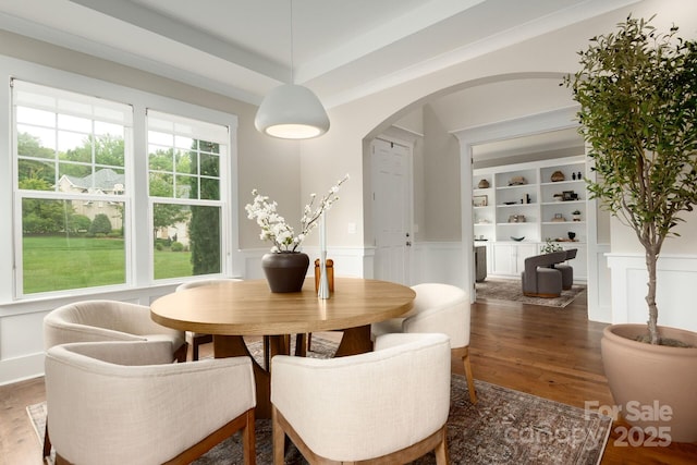 3009 Ocaso Ct, Matthews, NC 28104 - dining area with arched walkways, wood finished floors, a wainscoted wall, and a decorative wall