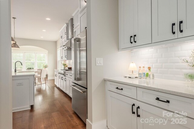 3009 Ocaso Ct, Matthews, NC 28104 - kitchen featuring high quality fridge, dark wood-type flooring, backsplash, recessed lighting, and white cabinetry